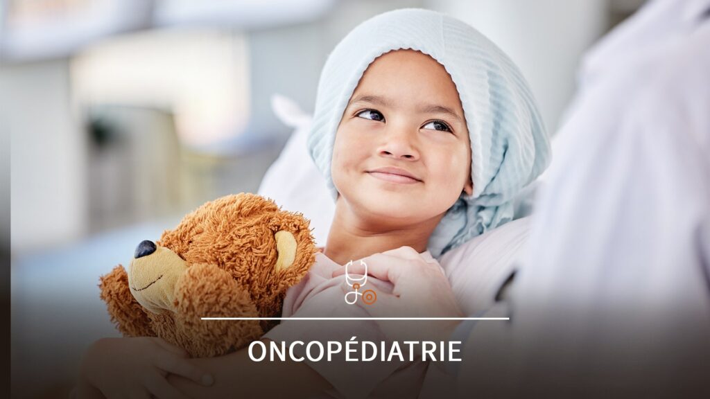 Petite fille qui sourit, avec une peluche nounours dans les bras et un foulard sur la tête pour cacher la perte de cheveux liée au cancer