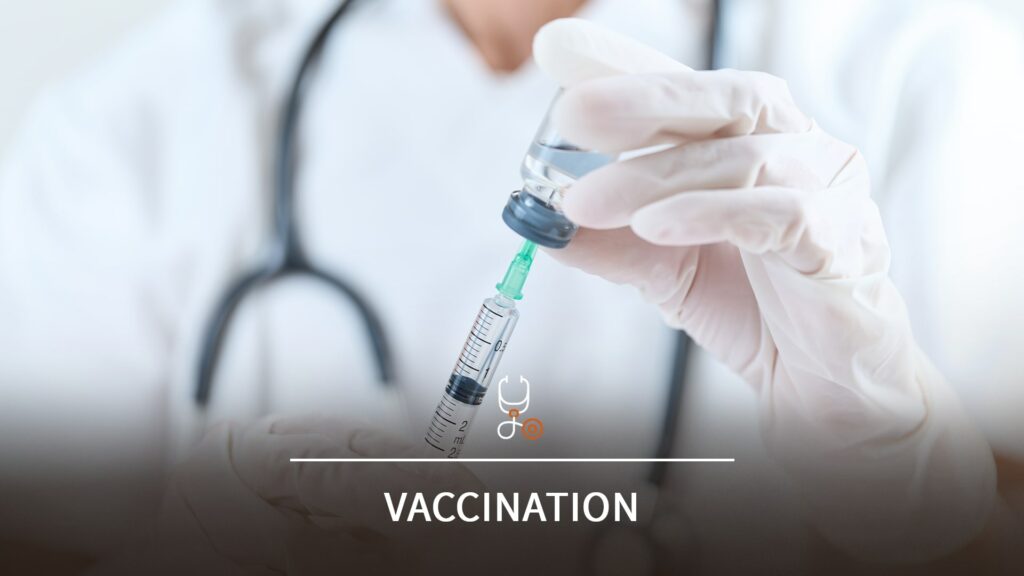 Professionnel de santé portant des gants et un stéthoscope autour du coup, qui prépare une seringue médicale en la remplissant avec un vaccin.