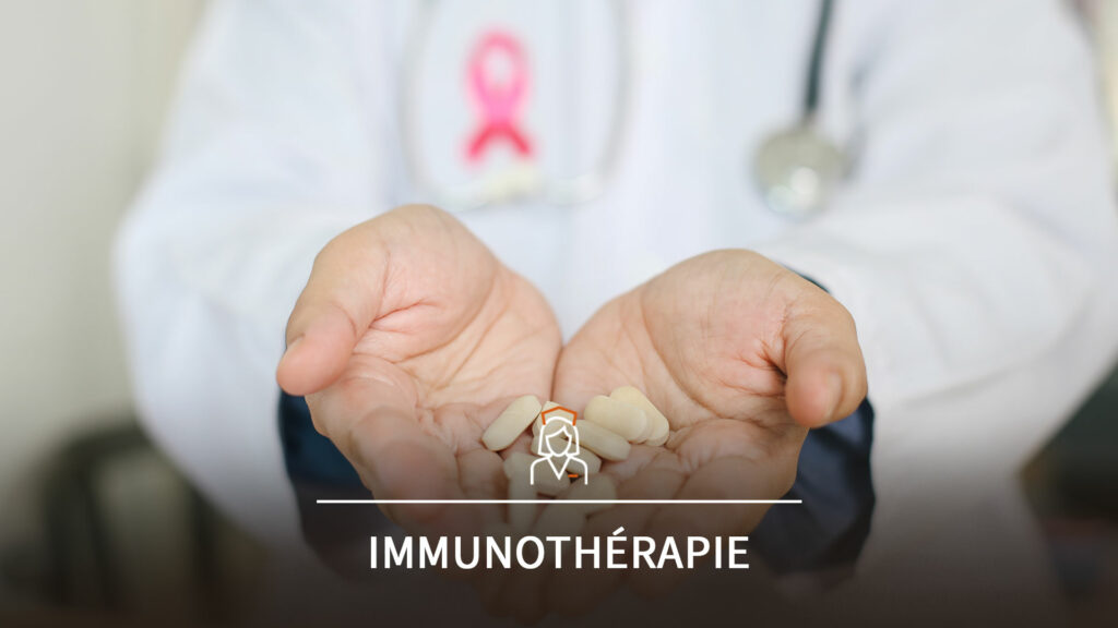 Un infirmier portant un ruban rose (symbole de la lutte contre le cancer) tends avec entre ses mains un traitement médicamenteux anticancéreux, lié à une thérapie orale ou une immunothérapie.