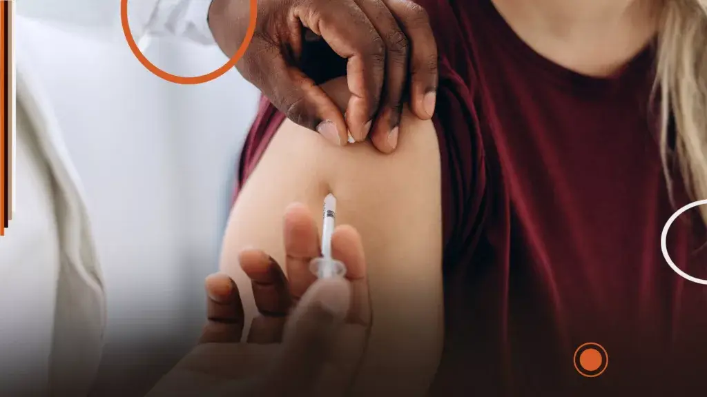 Professionnel de santé administrant un vaccin dans le bras d’un patient lors de la campagne de vaccination grippe et COVID-19 2025.
