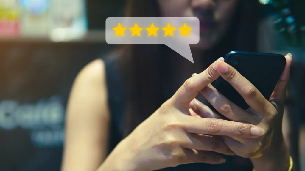 Personne consultant les avis et notes sur smartphone, illustrant l’importance des évaluations pour choisir un organisme de formation DPC.