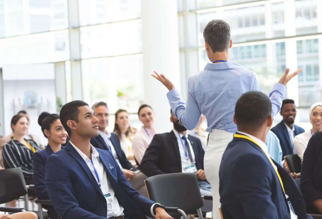 Professionnels participant à une session de formation en présentiel, avec une intervenante échangeant avec le groupe.