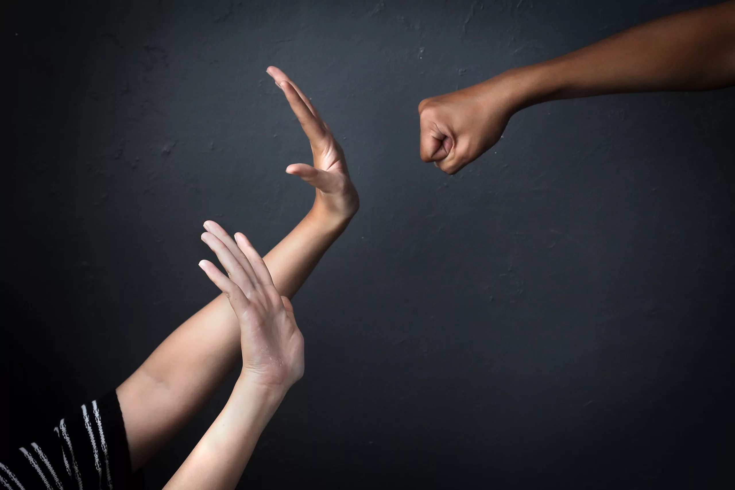 Main en position de défense face à une agression symbolisant les tensions et conflits professionnels