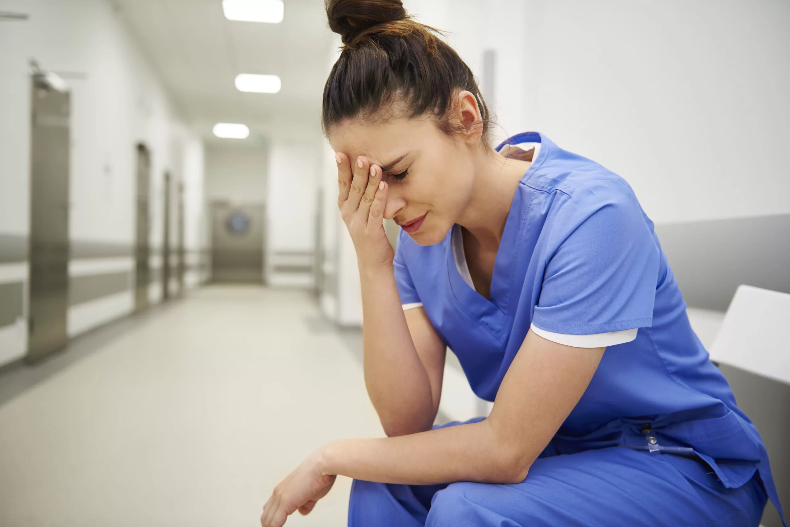 Infirmière épuisée dans un couloir d’hôpital illustrant le burn-out des professionnels de santé